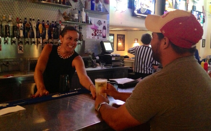 Bar owner Marci Dickerson of Las Cruces, N.M., serves a customer a beer.