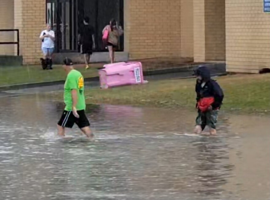 Vendors wade through knee-high water near the Expo Center at the New York State Fair. Photo taken around noon.