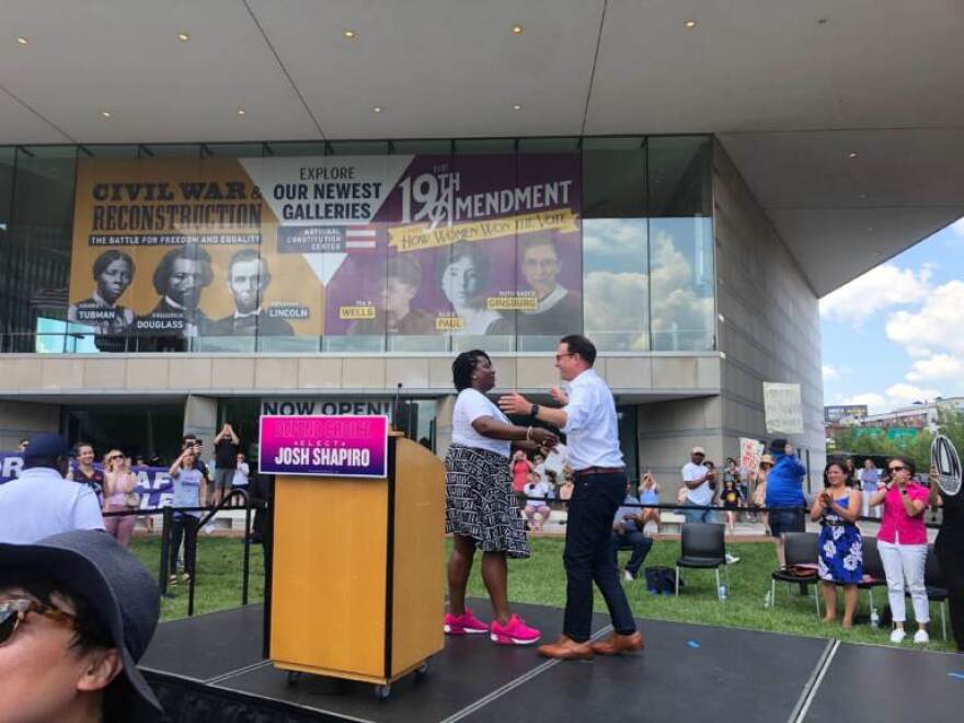 House Minority Leader Joanna McClinton embraces Josh Shapiro as he walks on the stage to rally for abortion rights.