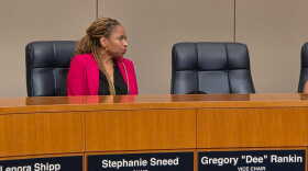 Woman at dais in pink jacket