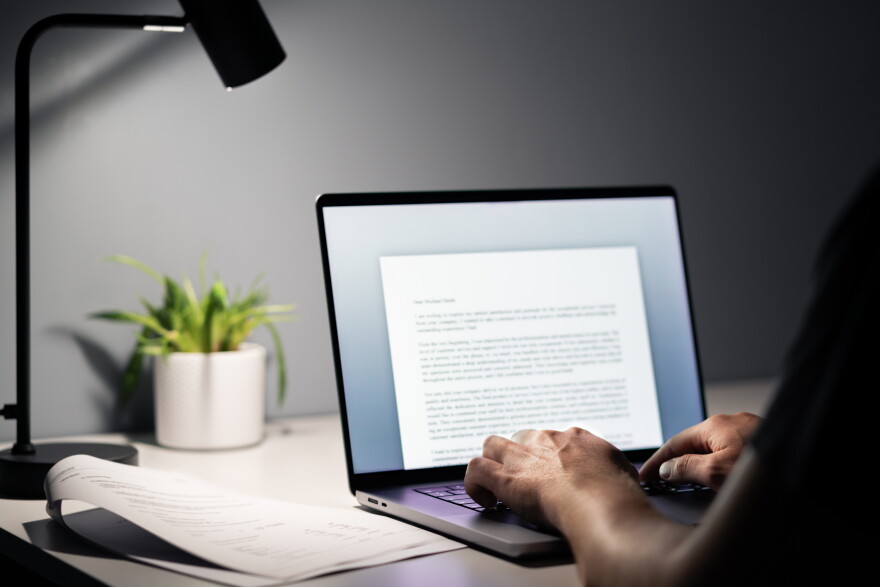 Man writing text document, essay or letter with laptop. Freelance writer, journalist or entrepreneur working late at night, overtime. Job seeker, cv resume and application. Dark home or office room.