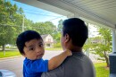 Marcial holds baby Sergio at home