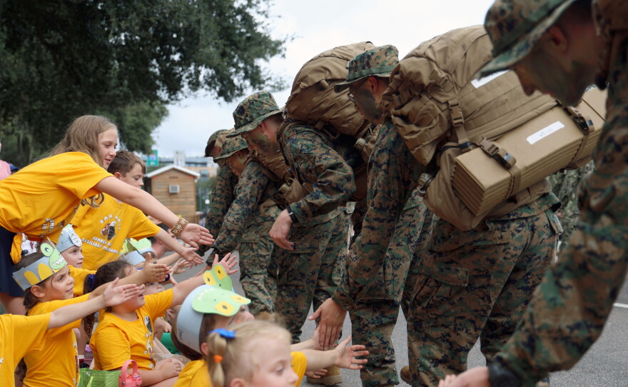 Students from Oak Hall School high-five University of Florida students in UF's Army ROTC program during the University of Florida Homecoming parade in Gainesville Friday, Oct. 9, 2026. (Alessia Lavayen/WUFT News)