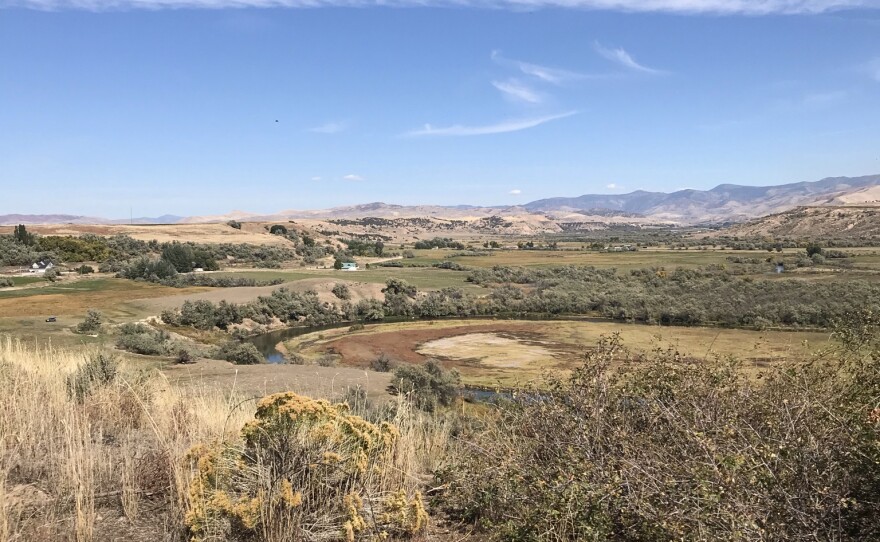 A view of a river and surrounding farmland from a ridge