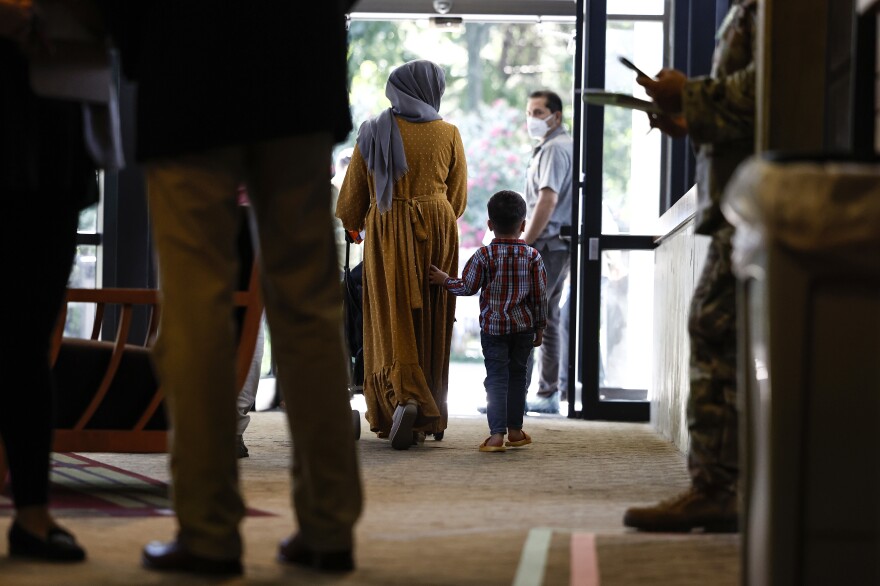 An Afghan woman and her son walk through the National Conference Center, redesigned to temporarily house Afghan nationals, on Aug. 11 in Leesburg, Virginia. Operation Allies Welcome recently turned the NCC into a hotel-like location where Afghan nationals who recently left Afghanistan can begin the process of resettling in the United States.