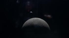 View of the moon in the foreground and the Earth in the distance