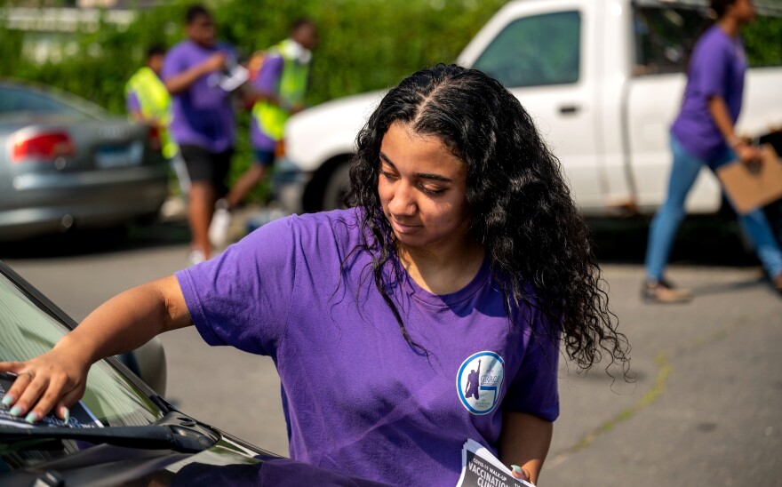 Antonia Capizza canvasses a Waterbury neighborhood delivering COVID-19 vaccination information.