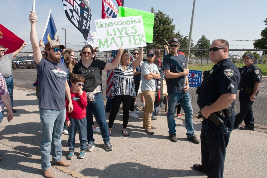 People gather at the National Interagency Fire Center to protest President Joe Biden’s visit to Boise on Sept. 13, 2021. Many brought signs to protest vaccine regulations proposed by the Biden administration to combat the spread of the coronavirus. (Jim Max/For the Idaho Capital Sun)