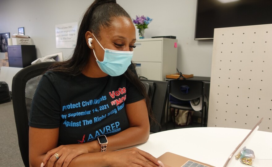 Keyva Clark, a volunteer for the African American Voter Registration, Education and Participation Project, scrolls through a list of registered voters to call to encourage them to vote in the Sept. 14 California recall election.
