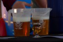 Two pitchers of beer and a glass of beer sit on the table of the Moontown Brewing Company booth. The pitcher shows the Moontown logo, a flour with wheat, and the slogan "Keep it Dank."