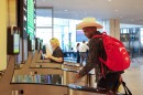 Man in cowboy hat and wearing a backpack walks through an airport security gate.