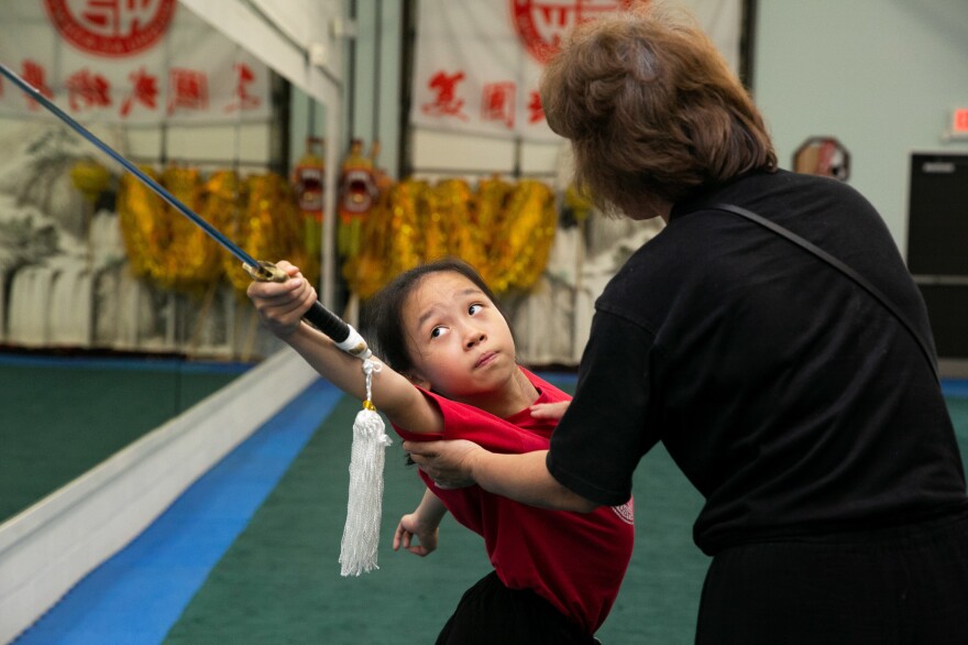 Twelve-year-old Ellen Yang practices her performance for the USAWKF National Team Trials while Zhang corrects her form.