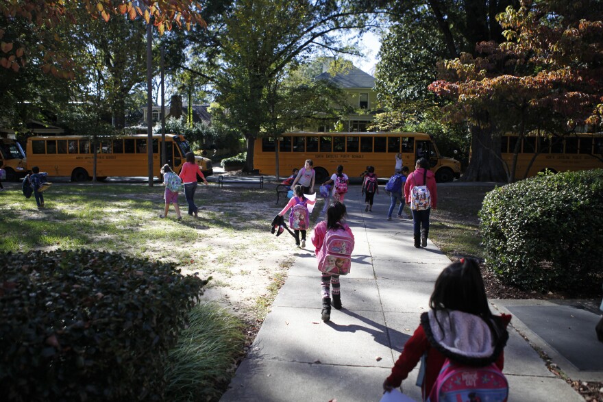 The end of the day at Watts feels like a party in front of the school. Some students rush to board buses while parents and teachers mingle.
