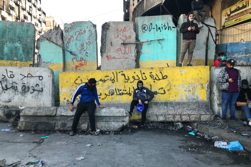 Protesters near Baghdad's Tahrir Square. The concrete barriers have been erected by security forces who are trying to prevent demonstrations from moving closer to Baghdad's fortified Green Zone.