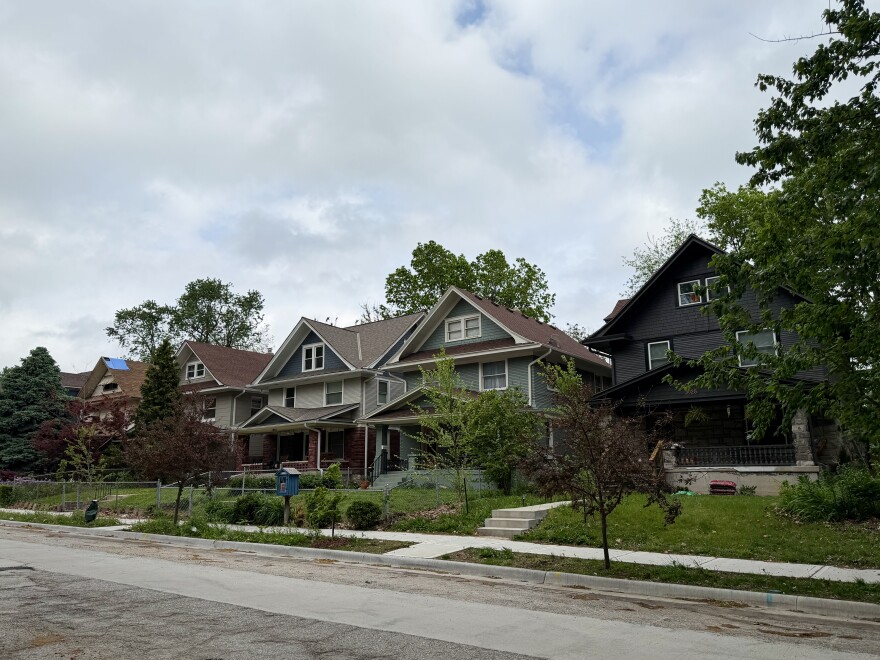 A row of homes stand next to each other on a block.
