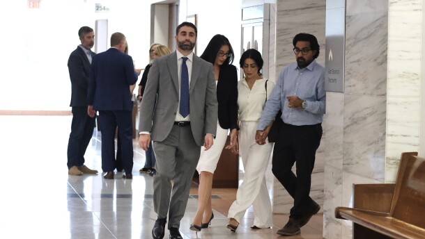 Omar Ahmed and Nausheen Gilkar, right, walk in with their lawyers to a hearing regarding a temporary restraining order against surrogate McKenna West Tuesday, Aug. 25, 2026, in Dallas.