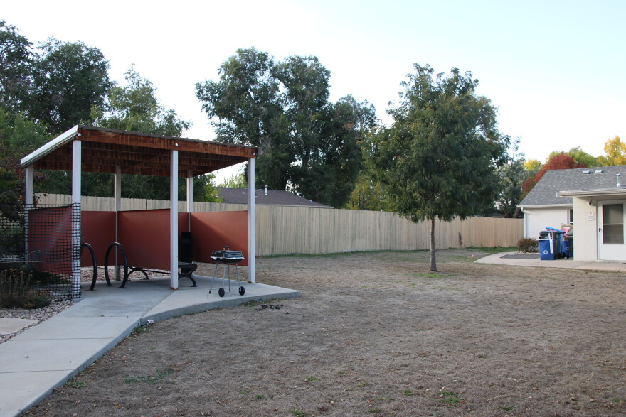 A backyard with grass and a small shade structure.