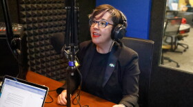 Mayor Barbara Buffaloe sits in a recording booth. She's wearing headphones and a dark blazer. She's speaking into a microphone.