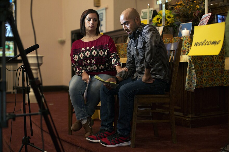 Carly Garcia comforts her husband, Alex, as he nervously reads from a prepared statement during an interview with a TV news station from Poplar Bluff.