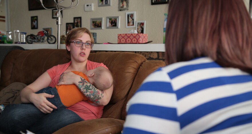 Samantha Hanaway, left, holds her son as she meets with Kourtney Waganer, a family support specialist with Parent Promise.