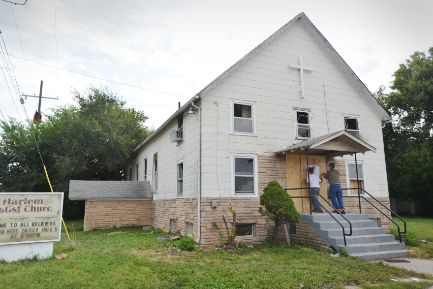  Workers shutter the front door of Harlem Baptist Church on Sept. 20, 2021 shortly after a fire destroyed part of the building.