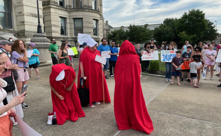 Three women dressed as characters from the Dystopian classic, The Handmaid's Tale