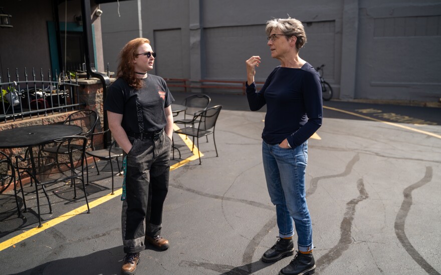 Riley DeCavitch and Amy Eddings speaking in a parking lot.