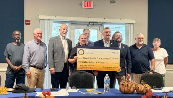 Officials hold a ceremonial check after receiving word of $16 million in state funding to help pay for a water treatment plant in Sturgis, KY