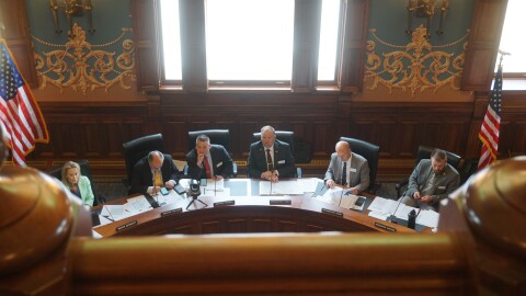 Some people sit at a big, curved desk.