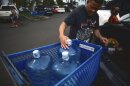 Washington state resident Poppy Mellon fills his car with jugs of water in preparation for the tsunami threat at the Kapolei Walmart, Hawaiʻi, Tuesday, July 29, 2025.