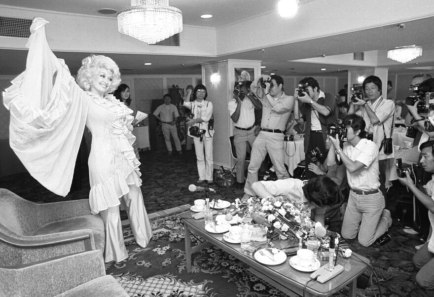 Dolly Parton poses for Japanese press photographers at a Tokyo press conference, Monday, July 23, 1979. (AP Photo/Tsugufumi Matsumoto )
