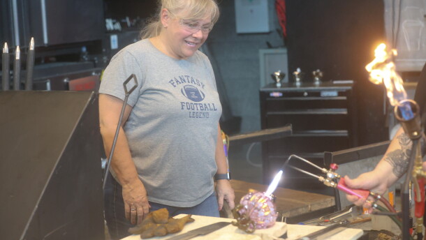 Norfolk resident Margaret Gemski watches as the final touches are applied to the pumpkin she created from glass.