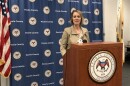 Peoria County State's Attorney Jodi Hoos stands at a podium in front of a county banner next to a U.S. flag as she speaks to reporters during an April 2022 news conference.  