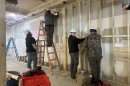Four young men in hard hats working on a construction site