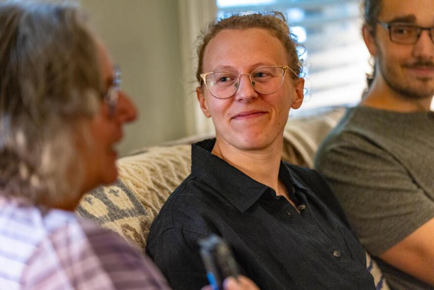 Jacqui Comstock smiles as she listens to Pam McColl speak during a conversation with her gene family. (Jesse Costa/WBUR)