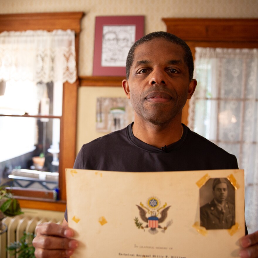 David McGhee holds up an award given to his grandfather, Sgt. Willie F. Williams, for his military service in World War II.