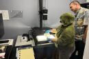 A digitization specialist, left, and State archivist Adam Jansen scan a photo of Punahou School's Dillingham Theater. ( Sept. 5, 2025)