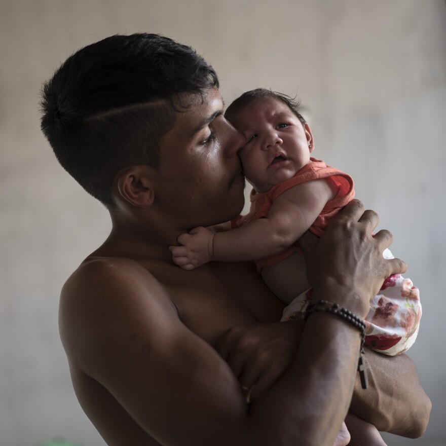 Dejailson Arruda holds his daughter, Luiza, at their house in Santa Cruz do Capibaribe, Pernambuco state, Brazil, in this December 2015 photo. The child was born with microcephaly.