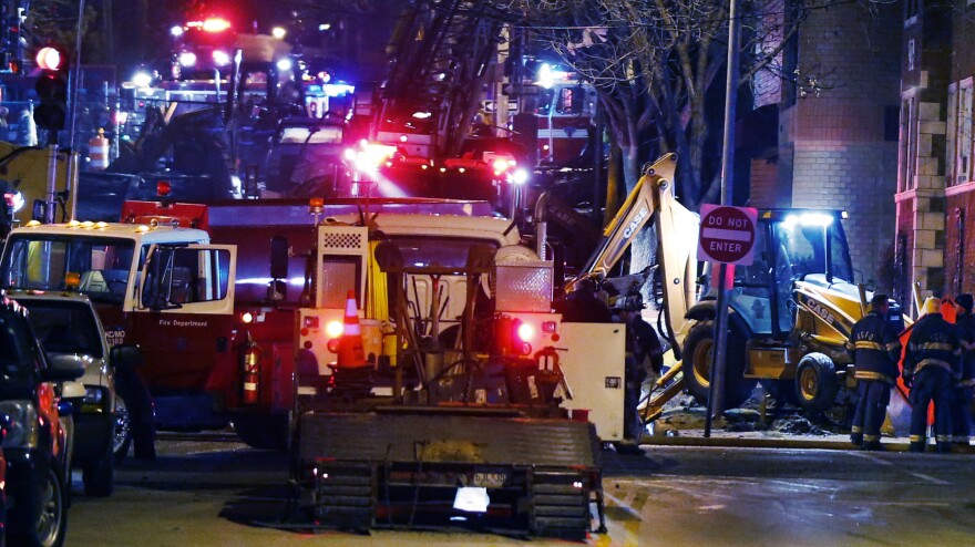 Fire fighters and utility workers at the scene of a massive gas explosion and fire Tuesday night in Kansas City, Mo.