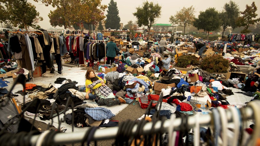 An evacuee of the Camp Fire pauses to hug her son as they volunteer sorting clothes at a makeshift shelter in Chico, Calif.