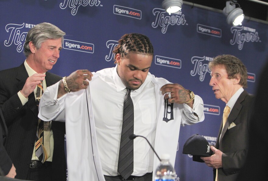 Detroit Tigers president, CEO and general manager Dave Dombrowski, left, helps new Tigers first baseman Prince Fielder with his uniform as team owner Mike Ilitch looks on during a baseball news conference at Comerica Park in Detroit on Thursday.