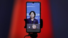 A smartphone records Chinese Foreign Ministry spokeswoman Hua Chunying as she speaks during a daily briefing at the Ministry of Foreign Affairs in Beijing. "I'd like to stress that if the United States truly respects facts, it should open the biological lab at Fort Detrick, give more transparency to issues like its 200-plus overseas bio-labs, invite WHO experts to conduct origin-tracing in the United States," she said at a January 2021 MOFA press conference that went viral in China. (Andy Wong/AP)