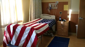 A hospital bed is draped with a flag after a veteran died in the hospice ward at St. Albans VA in Queens, N.Y.