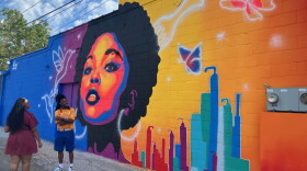 Rock Island artist Zay Williams celebrates the dedication of his new mural on the side of Celebrity's Beauty Supply, 1600 Harrison St., Davenport, on Friday, Sept. 4, 2026.