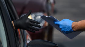 A man collects unemployment forms at a drive through collection point outside John F. Kennedy Library in Hialeah, Florida.