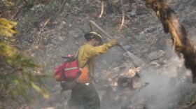 A firefighter mops up during the Milepost 97 fire in early August. near Canyonville, OR 