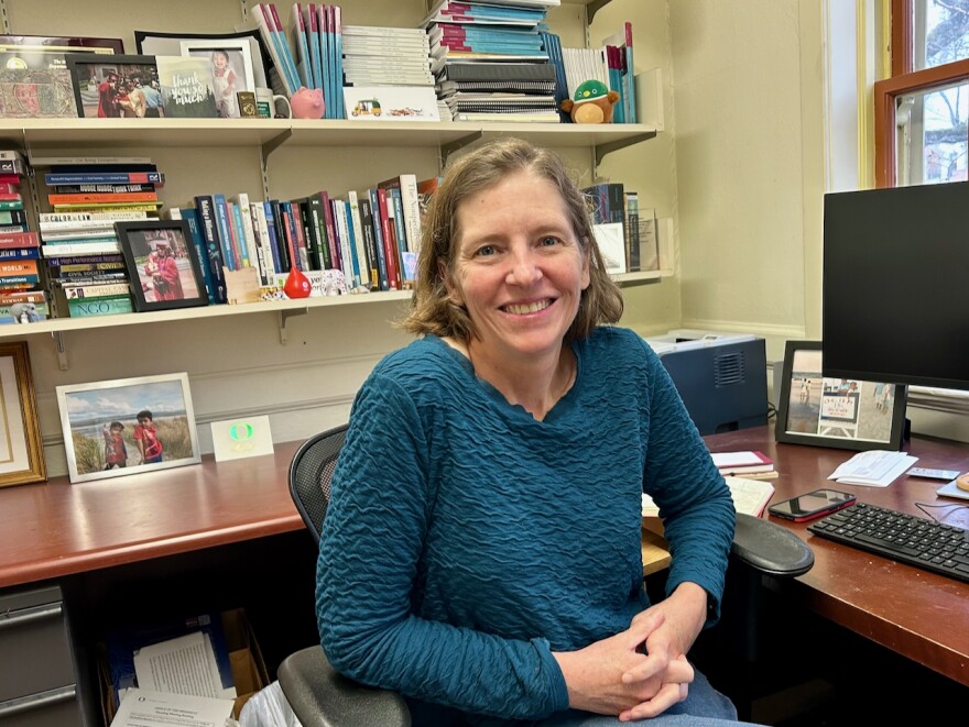 A woman at a desk turns for the camera