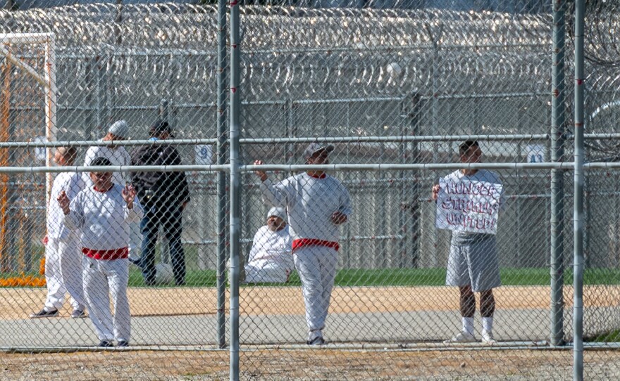 A detainee inside the Golden State Annex detention center in McFarland holds a sign that reads “Hunger Strikers United.”