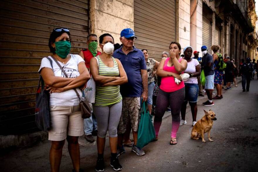 HOLD MY PLACE Cubans wait in line for food to become available at a store in Havana last year.