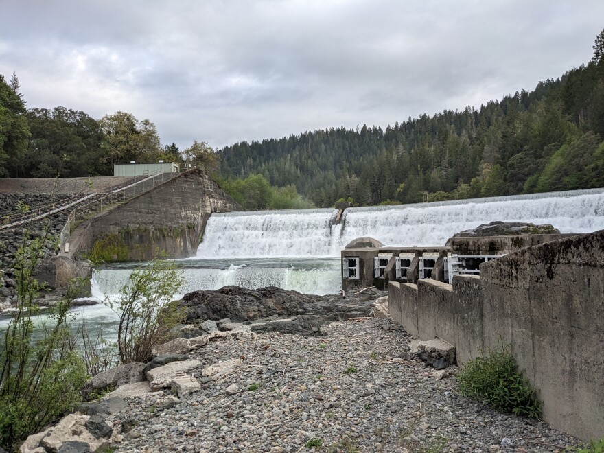 A dam, with water pouring into a river.